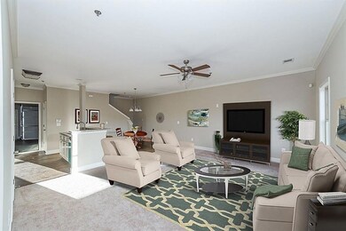 Living room with ceiling fan, crown molding, carpe