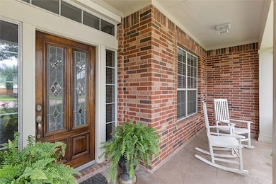 Super cute front porch with stamped concrete has room for rocking chairs.