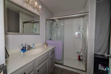 Full bath with a shower stall, tile patterned floo