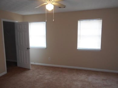 Spare room with light carpet, baseboards, and a ce