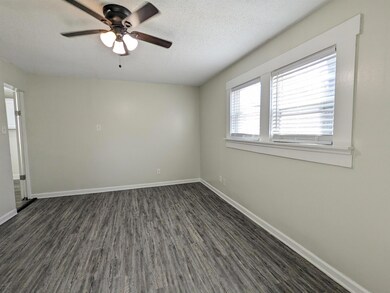 Empty room featuring dark wood-style floors, a ceiling fan, and a textured ceiling