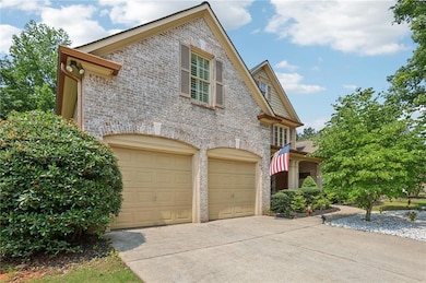 View of front facade featuring concrete driveway, brick siding, and a garage