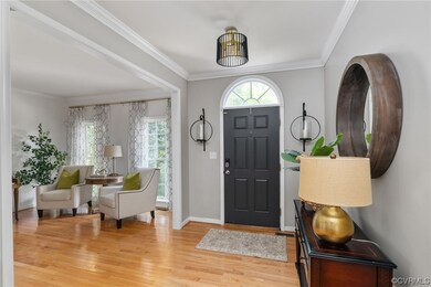 Entryway featuring ornamental molding and light ha