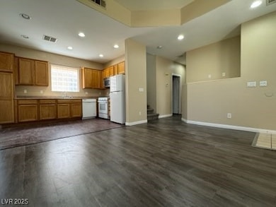 Kitchen featuring white appliances, dark wood-styl