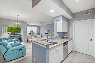 Kitchen with open floor plan, dishwasher, a sink, light stone counters, and white cabinets