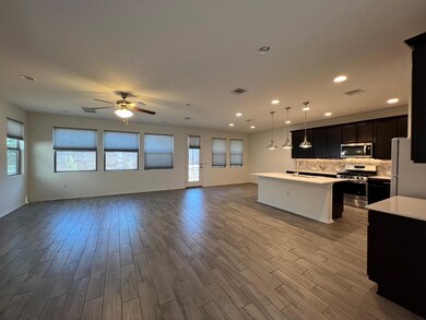 Kitchen featuring dark cabinets, open floor plan,