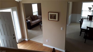 View of entry from stairs showing access to living room and dining room