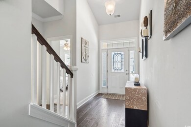 Entrance foyer featuring dark wood-style flooring, stairway, plenty of natural light, and ceiling fan