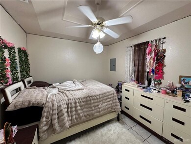 Tiled bedroom featuring electric panel and ceiling fan