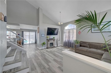 Living room featuring high vaulted ceiling, stairw