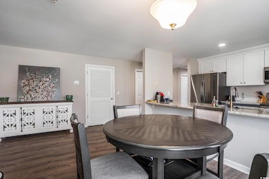 Dining room featuring dark wood finished floors, recessed lighting, and baseboards