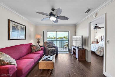 Living area with ceiling fan, dark wood-style floo