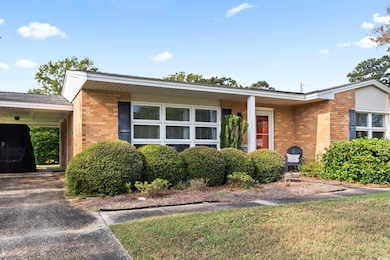 Single story home with a carport and a front yard