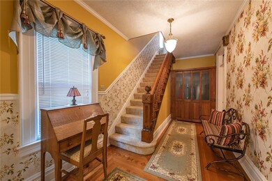 Grand entryway with original hardwood staircase.
