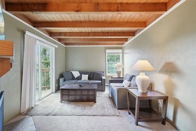 Living area with a wood ceiling with exposed beams