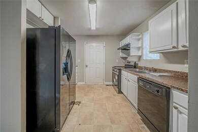 Kitchen featuring white cabinets, sink, and black 