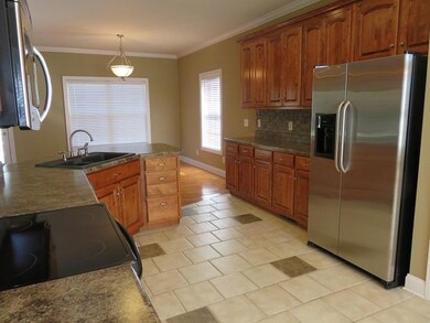 Beautiful Kitchen with tile floors, countertops, stainless steel appliances & tile backsplash