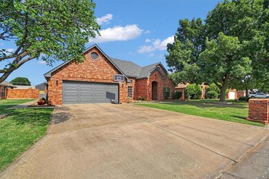 Traditional-style house featuring brick siding, driveway, an attached garage, and a front lawn