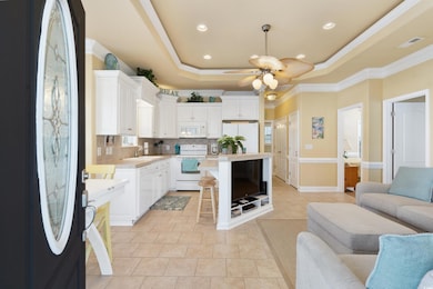 Kitchen with a tray ceiling, open floor plan, deco