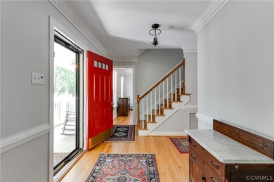 Foyer featuring light hardwood floors and crown mo