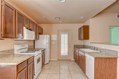 Kitchen featuring white appliances, light tile patterned flooring, light stone countertops, brown cabinets, and recessed lighting