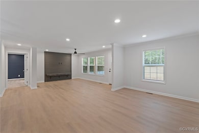 Unfurnished living room featuring baseboards, orna