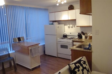 Kitchen featuring white appliances, a sink, dark 
