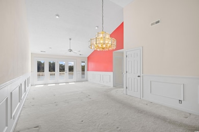 Carpeted empty room featuring visible vents, a dec