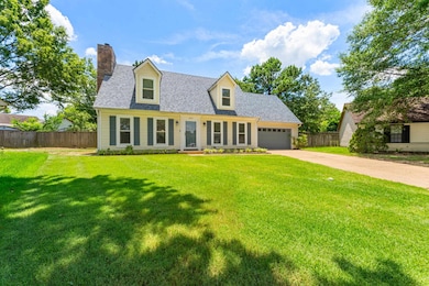 Cape cod home featuring a chimney, concrete driveway, an attached garage, and roof with shingles