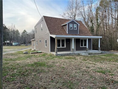Back of property with a yard and a porch