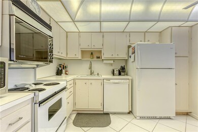 Large kitchen with white cabinets and appliances a