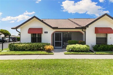 View of front of property with a front yard, a shingled roof, and stucco siding