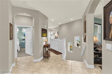 Hall with an upstairs landing, recessed lighting,