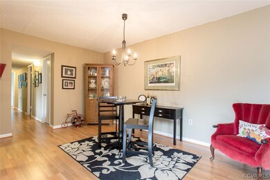 Dining room with wood laminate floor & chandelier.