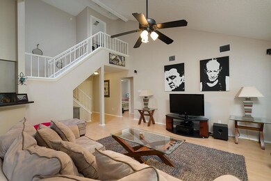 Living area featuring a ceiling fan, wood finishe