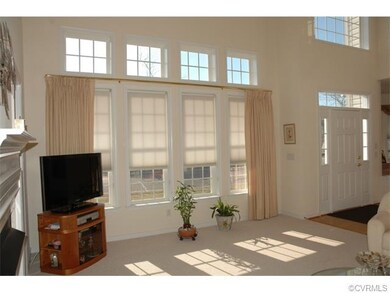 Sunny, two story living room with wall of windows 