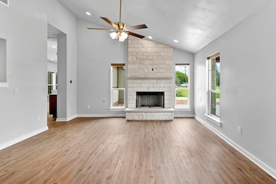 Unfurnished living room featuring ceiling fan, wo