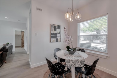 Dining space with light wood finished floors and a chandelier