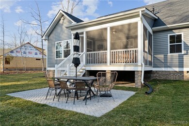 Rear view of property with a patio, a yard, a shingled roof, and a sunroom