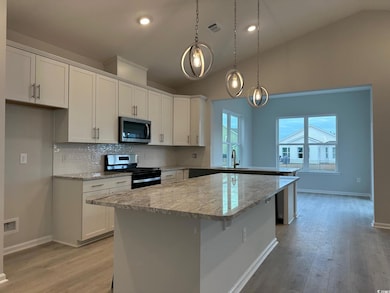 Kitchen featuring light stone countertops, stainle