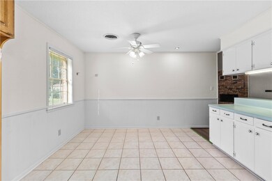 Kitchen with ceiling fan, a wainscoted wall, white