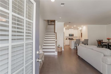 Living area with dark wood-style flooring, stairway, recessed lighting, and baseboards