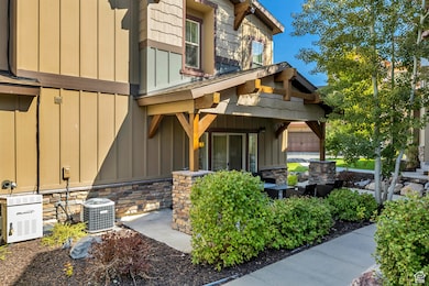 View of exterior entry featuring board and batten siding, stone siding, and covered porch