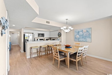 Dining area with light wood-style flooring and a chandelier