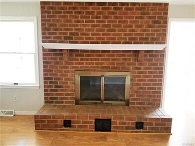 Family room features a brick wood burning fireplac
