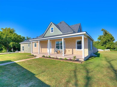 View of front of house with a front yard and a por
