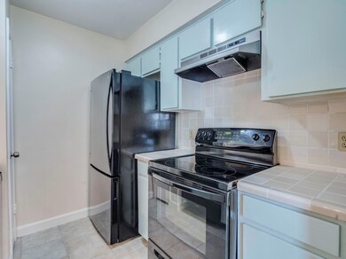 Kitchen featuring black appliances, tile countert
