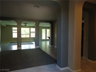 Corridor with baseboards, visible vents, arched wa