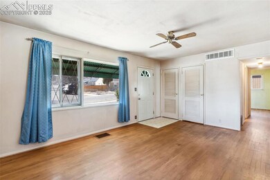 Foyer entrance with large window, ceiling fan, and