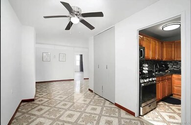 Kitchen with decorative backsplash, stainless steel appliances, brown cabinetry, a ceiling fan, and dark stone countertops